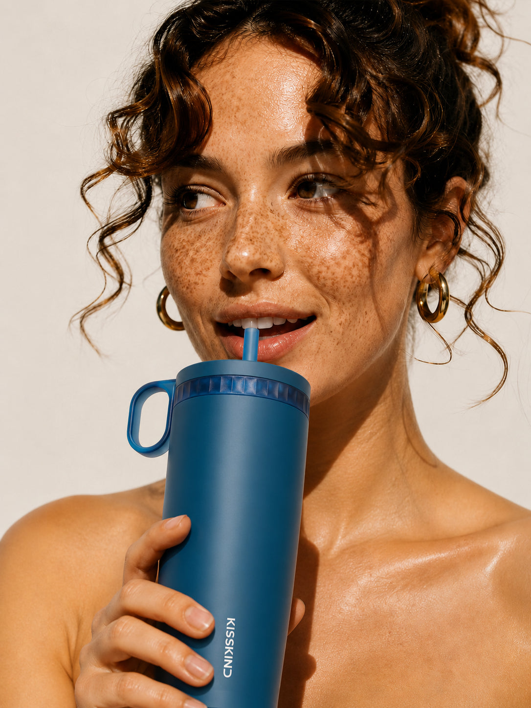 Person taking the first sip from a Kisskind iced-coffee cup