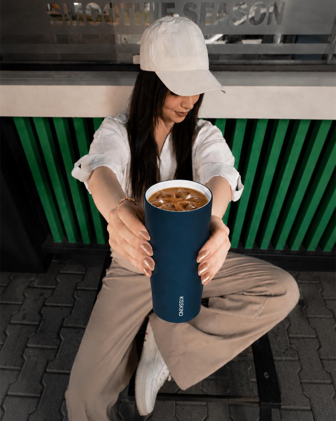 Blue KissKind cup in a cafe seating scene
