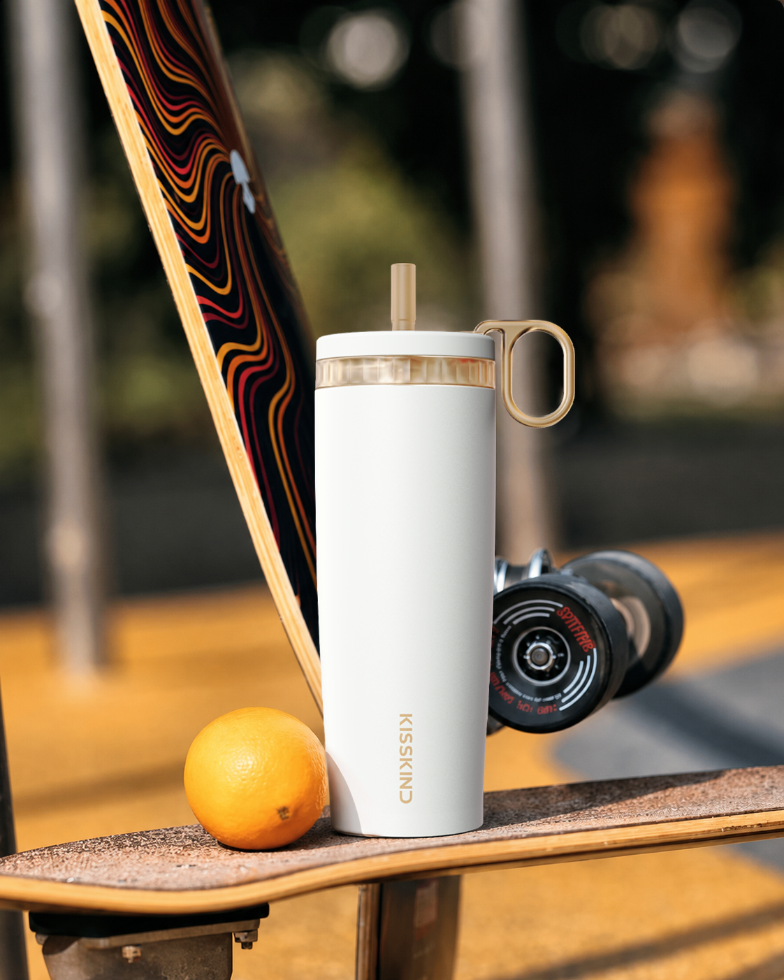 White Kisskind cup styled with a skateboard and everyday gear in warm outdoor light