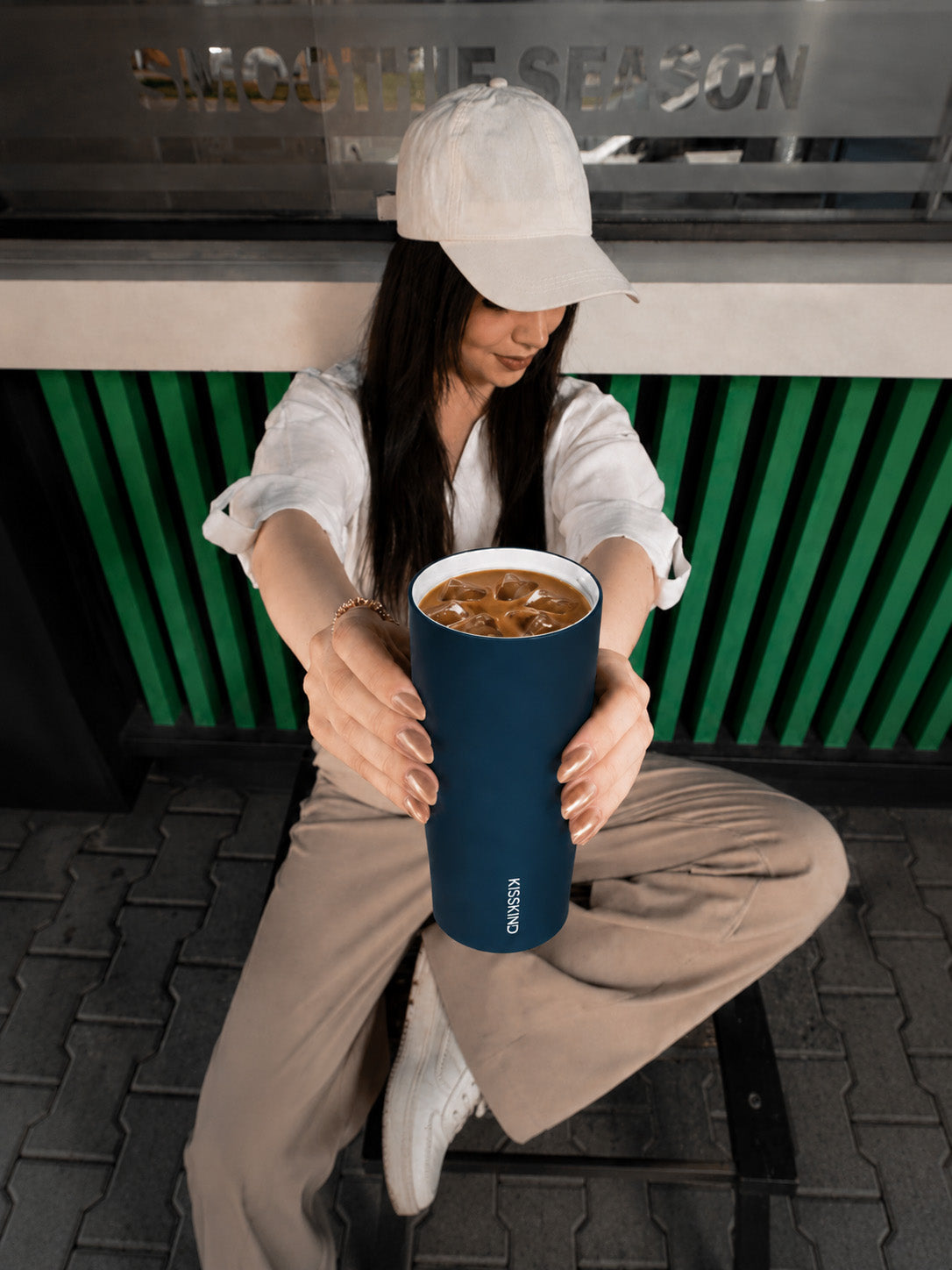 Person enjoying iced coffee in a softly lit cafe