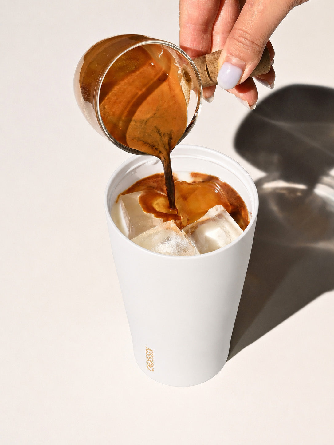 Fresh iced coffee poured into a cream Kisskind cup