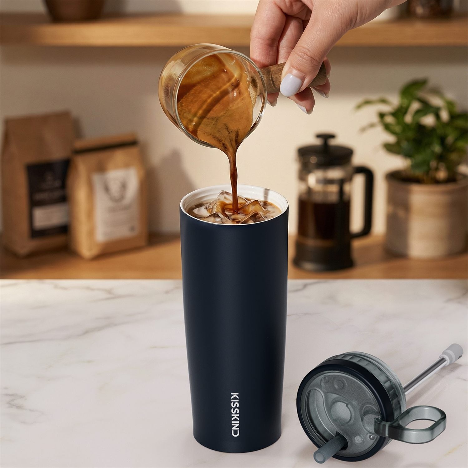 Iced coffee poured into a ceramic-lined KissKind tumbler.