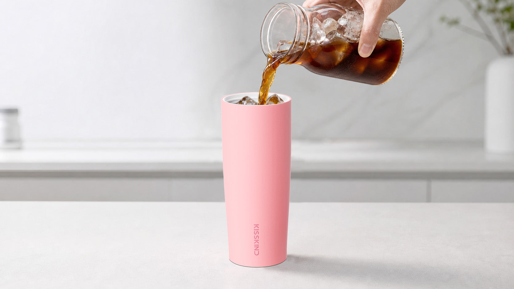 Iced coffee poured into a pink KissKind cup